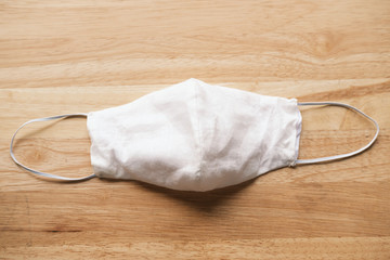 homemade white cloth masks for protection against coronavirus (COVID-19) on wooden table medium shot