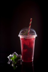 Refreshing cool lemonade with strawberries, mint and ice in plastic glass