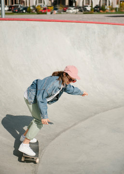 Young woman doing skateboarding trick outdoor in skate park
