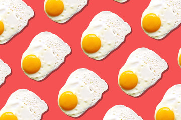 Fried egg or scrambled eggs pattern on coral background. Creative food concept. Top view. Conceptual trend. Banner. Keto diet. Healthy food print. Creative design for packaging.