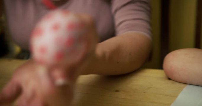 Preschooler and his mother painting easter eggs at a table