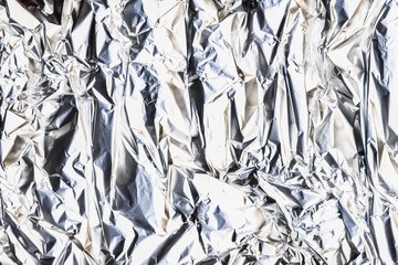 Metallic abstract background. Foil crinkled texture. Shiny silver crumpled design.