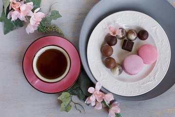 Morning cup of tea with chocolate and macaroons. Spring background. Breakfast flatlay