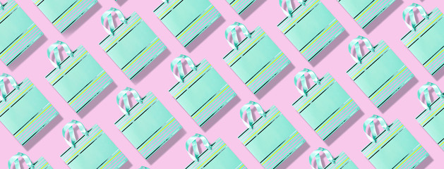 Top view of turquoise paper shopping bag pattern on trendy pink background. Copy space. Creative design for packaging. Gift concept. Woman's day. Valentine's day. Ready for birthday party.