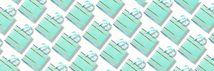 Top view of turquoise paper shopping bag pattern on trendy pink background. Copy space. Creative design for packaging. Gift concept. Woman's day. Valentine's day. Ready for birthday party.