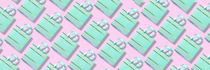 Top view of turquoise paper shopping bag pattern on trendy pink background. Copy space. Creative design for packaging. Gift concept. Woman's day. Valentine's day. Ready for birthday party.