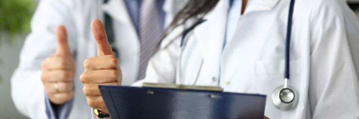 Group of doctors standing in row showing thumb up symbol