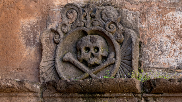 Ornament with a skull and crossbones above the chamber of ancient religious inquisition at cusco cathedral in peru.