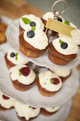 Delicious cupcakes stand on a multi-story stand with a flag at the very top. Healthy food for the holiday and party or birthday. View from above