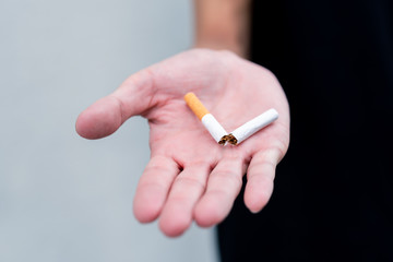 Stop smoking and Quit smoking cigarettes concept. Handsomeman holding broken cigarette in hands. Quit bad habit, health care concept.