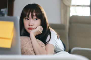 Asian teenager woman learning via internet with laptop in new normal lifestyle.