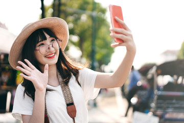 Young asian influence girl traveling in bangkok with smartphone for upload to social network.
