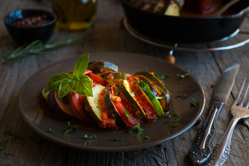 Homemade ratatouille made with sliced vegetables: zucchini, tomatoes and eggplant. Delicious vegan dish