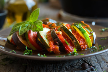 Homemade ratatouille made with sliced vegetables: zucchini, tomatoes and eggplant. Delicious vegan...