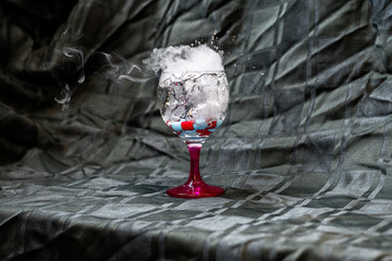 Glass of water with water and smoke splash in it