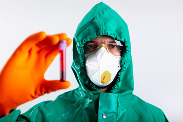 Man in hazmat suit with blood sample in hand against the white background