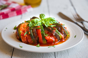 Homemade ratatouille made with sliced vegetables: zucchini, tomatoes and eggplant. Delicious vegan dish