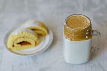 dalgona coffee and homemade biscuit on a light marble background