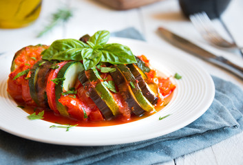 Homemade ratatouille made with sliced vegetables: zucchini, tomatoes and eggplant. Delicious vegan dish