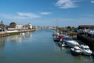 Fototapeta premium The beautiful River Arun meandering it's way past Littlehampton with boats moored on each side on a sunny day in May.