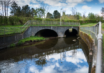 Fototapeta na wymiar Double drain under road for small river. Big pipe under freeway, engineering roadmaking.