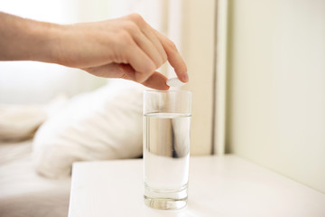 Male Hand Adds Aspirin Pill into Glass of Water. Healthy Life, Hangover, Pills Concept