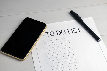 phone and ballpoint pen on the table, a to-do list for today to be completed. concept of memory and...