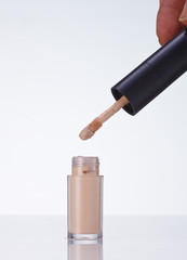 Makeup concealer and container in white background