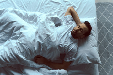 Calm handsome man sleeping on white linen