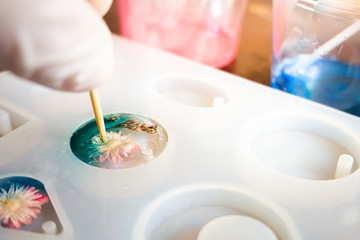 Rearrange dry flower in making personal accessories from resin