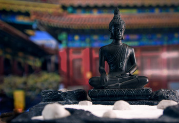 figurine of a religious Buddha on the background of a temple close up rock garden