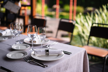 a table with a white tablecloth, white dishes are on the table