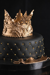 Black cake with a Golden crown of mastic