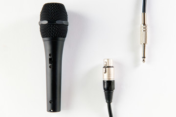 Obraz premium Top view of black microphone with XLR and mono jack cable, isolated on white background.