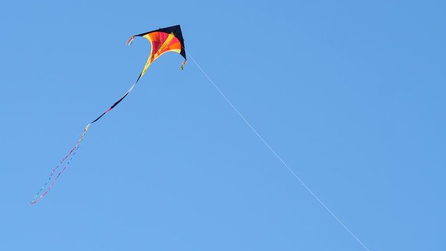 Colorful kite flying against a blue sky
