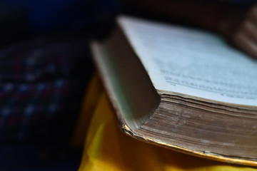 closeup of a Indian girl reading a holy ramayan and bhagwat geeta at home, with blur background.