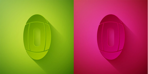 Paper cut American Football ball icon isolated on green and pink background. Rugby ball icon. Team sport game symbol. Paper art style. Vector Illustration