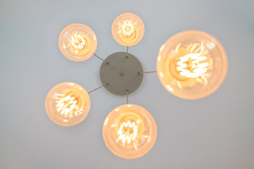 round chandeliers of different diameters with warm light on the white ceiling