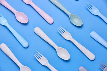 Plasic fork, spoon and knife on black background, top view