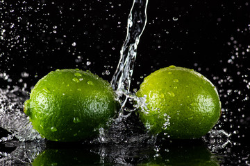 Fototapeta na wymiar lime with splashes and streams of water on a black or white background isolated