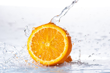sliced orange with a splash and a stream of water on a white or black background