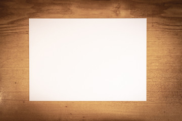clean blank white paper on a dark wooden table. old wooden background.