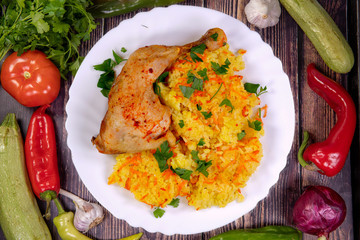 Tasty chicken with rice and spices on a white plate, top view