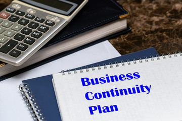 The text of the business continuity plan is written on a white sheet lying on the office Desk.