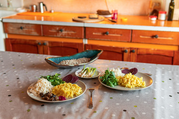 Ready nourishing and healthy food for two persons on the table including rice, greens, cabbage, beet, bread, fresh garlic, sunflower seeds, mushrooms and horseradish