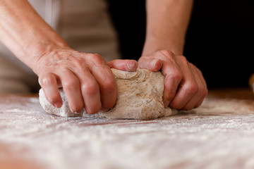 a person kneading the whole pizza dough 