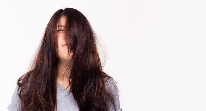 Her long hair get messy and little bit frizzy because beautiful asian woman does not go to hair salon for long time. Young female having a bad hair day, her hair is very messy, tangled. copy space