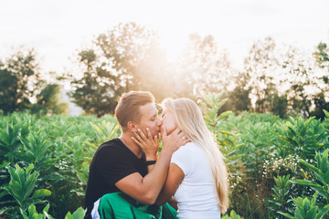 Love story of a couple, engagement in summer on a green field