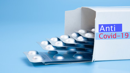 Anti-virus capsules COVID-19 packed in a white box isolated on blue background, Front view Blank for design copy space..