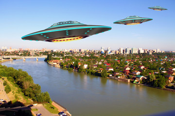 A metal and silver UFO invasion of planet Earth, a group of spaceships fly in the sky above the city and emit yellow rays to the earth. 3D rendering © OlegKachura
